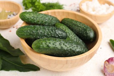 Hafif arka planda korunması için taze salatalıklı bir kase.