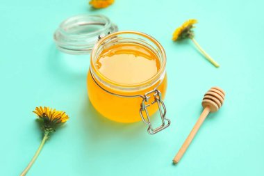 Turkuaz arka planda karahindiba balı kavanoz.