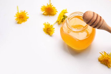 Beyaz arka planda karahindiba balı kavanoz