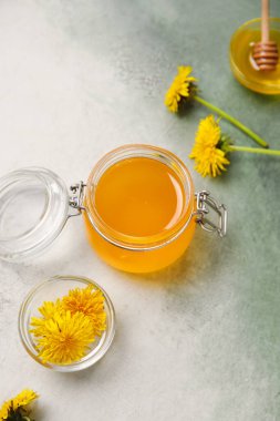 Kavanoz ve kâselerle beyaz arka planda karahindiba balı