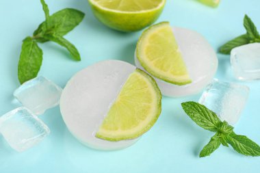 Mavi zemin üzerinde buzun içinde donmuş taze limon dilimleri.