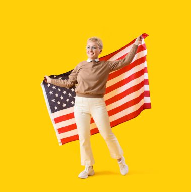 Sarı arka planda ABD bayrağı olan genç bir kadın.