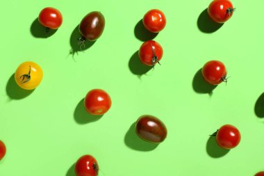 Yeşil arka planda farklı taze kiraz domatesleri.