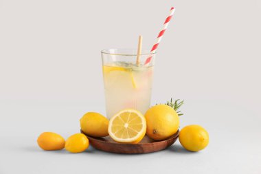 Gri zemin üzerinde taze limonata olan tabak ve cam.