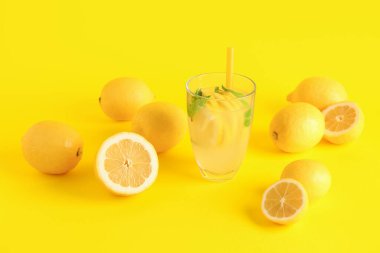 Taze limonata ve sarı arka planda limonlar.