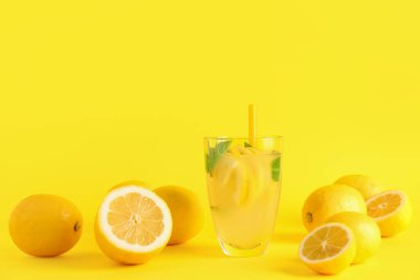 Taze limonata ve sarı arka planda limonlar.
