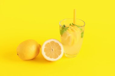 Taze limonata ve sarı arka planda limonlar.