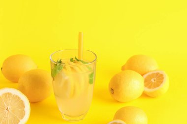 Taze limonata ve sarı arka planda limonlar.