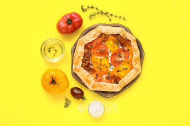 Sarı arka planda leziz domates galetesi olan tahta.