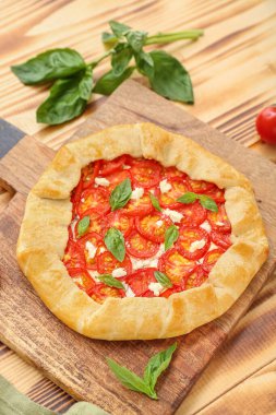 Lezzetli domates galeti ve ahşap arka planda fesleğen.