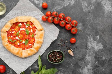 Lezzetli domates galeti ve gri arka planda fesleğen içeren kağıt fırını.
