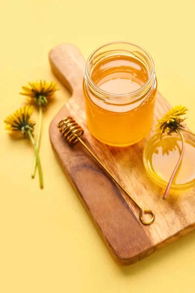 黄色の背景にタンポポの蜂蜜とボード 瓶とボウル — ストック写真