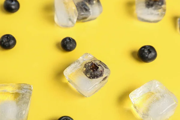 氷のキューブで冷凍ブルーベリーと黄色の背景に新鮮な果実を熟す — ストック写真