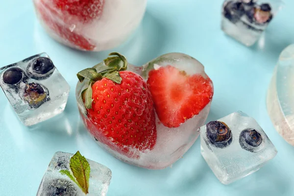 Frische Erdbeeren Und Blaubeeren Eingefroren Eis Auf Blauem Hintergrund — Stockfoto
