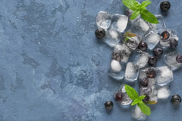 新鲜蓝莓冻在蓝色背景的冰块中 — 图库照片