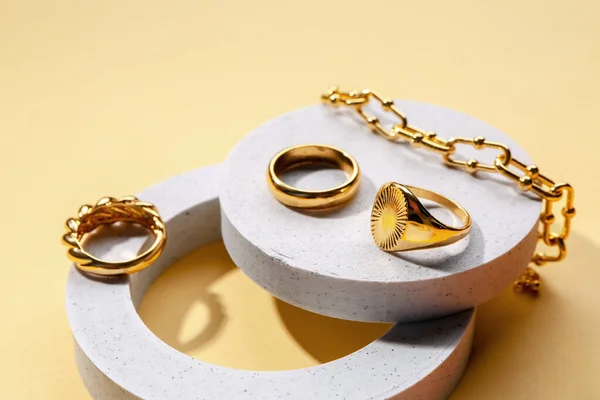Dekorative Podeste Mit Goldenen Ringen Und Armband Auf Farbigem Hintergrund — Stockfoto