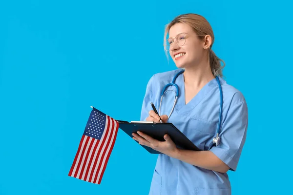 Female Doctor Usa Flag Writing Clipboard Blue Background — Stock Photo, Image
