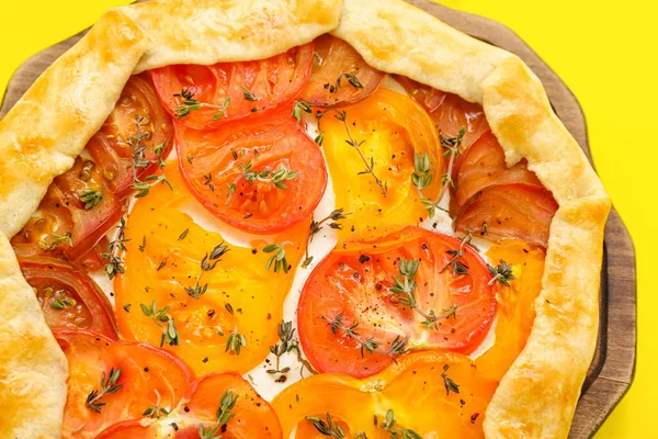 stock image Board with tasty tomato galette on yellow background