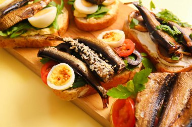 Ahşap tahtada sarı arka planda füme lahanalı lezzetli sandviçler var.