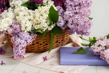 Beyaz fayans üzerinde güzel kokulu leylak çiçekleri olan bir sepet.