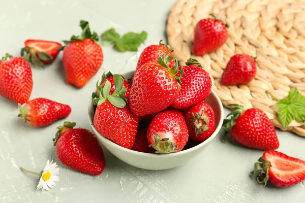 Schüssel Mit Frischen Erdbeeren Mit Blättern Und Kamillenblüten Auf Grauem — Stockfoto