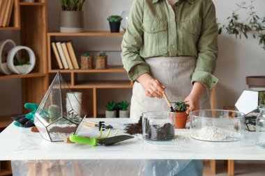 Evde sofrada çiçek yapan bir kadın.