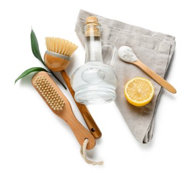 Sirke, fırça, kabartma tozu ve beyaz arka planda peçete.