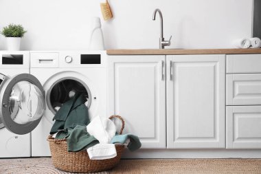 Çamaşır odasında kirli çamaşırları olan modern çamaşır makineleri.