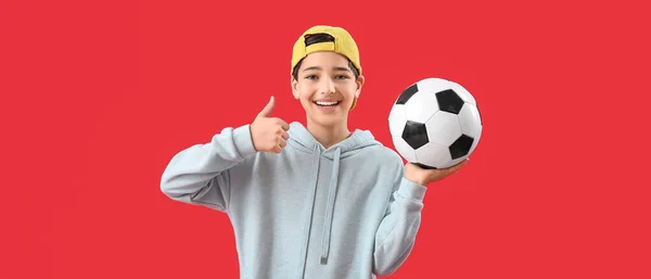 Mały Chłopiec Trzyma Piłkę Nożną Pokazuje Kciuk Góry Czerwonym Tle — Zdjęcie stockowe