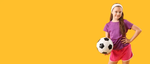 瘦小的小女孩拿着黄色背景的足球 上面有文字的空间 — 图库照片