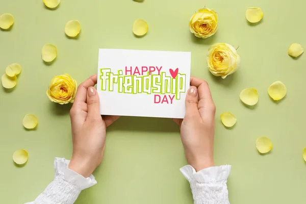 Weibliche Hände Mit Grußkarte Zum Tag Der Freundschaft Und Blütenblättern — Stockfoto