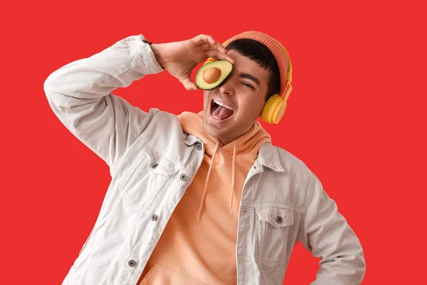 Ευτυχισμένος Νεαρός Άνδρας Ακουστικά Αβοκάντο Κόκκινο Φόντο — Φωτογραφία Αρχείου