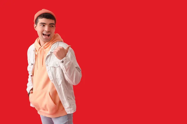 Stylish Young Man Pointing Something Red Background — Stock Photo, Image