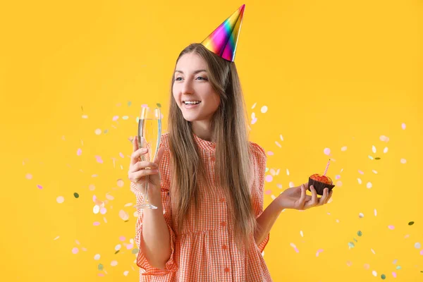 Gelukkige Jonge Vrouw Met Verjaardag Muffin Glas Champagne Gele Achtergrond — Stockfoto