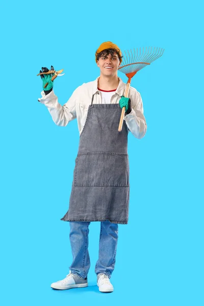 Male Gardener Secateurs Rake Blue Background — Stock Photo, Image