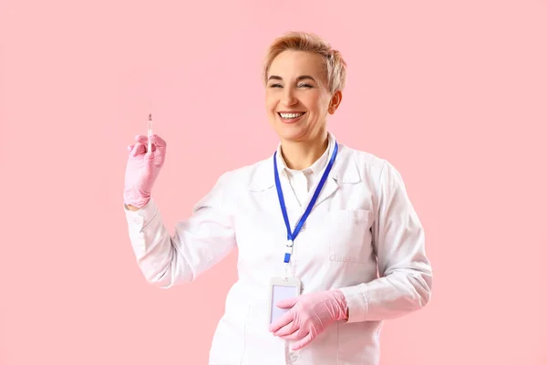 Érett Női Orvos Rózsaszín Hátterű Fecskendővel — Stock Fotó