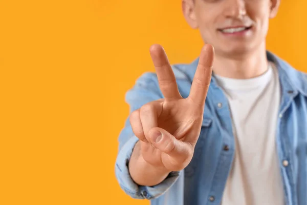 Mladý Muž Ukazující Dva Prsty Žlutém Pozadí Detailní Záběr — Stock fotografie