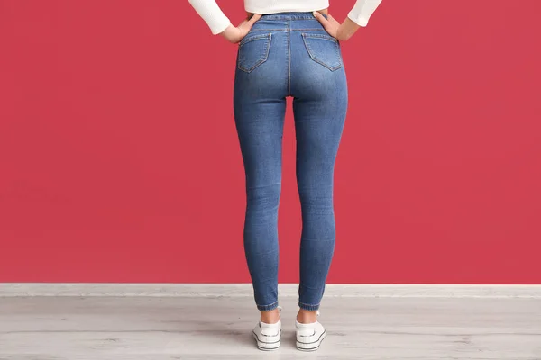 Jovem Mulher Jeans Elegantes Perto Parede Vermelha Vista Traseira — Fotografia de Stock