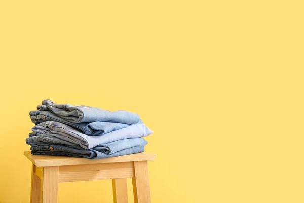 Taburete Con Jeans Doblados Sobre Fondo Amarillo — Foto de Stock