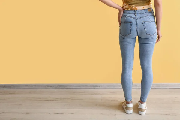Junge Frau Stylischen Jeans Nahe Der Gelben Wand Rückansicht — Stockfoto