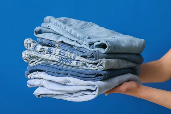 Mujer Con Jeans Doblados Sobre Fondo Azul —  Fotos de Stock