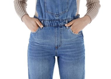 Beyaz arka planda kot tulumlu genç kadın, yakın plan.