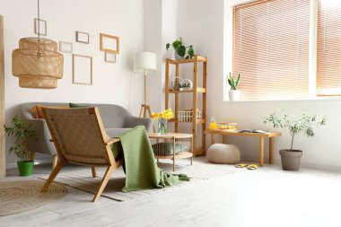 Gri koltuklu, tahta koltuklu ve kahve masalı aydınlık oturma odasının içi.