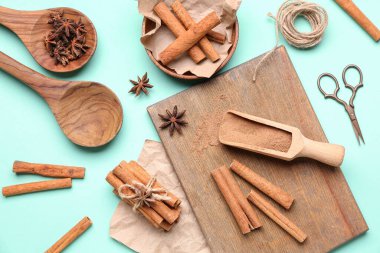 Tarçın çubukları, toz, anason yıldızları ve renk arkaplanındaki halatla kompozisyon