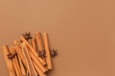 Renkli arkaplanda tarçın çubukları ve anason yıldızları yığını