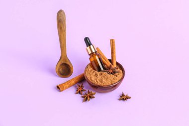 Tarçın tozu, sopa, yağ şişesi ve anason yıldızlı kase.