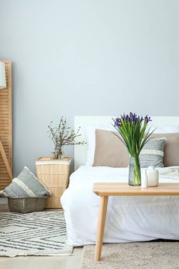 Masada çiçek açan süsen çiçekleriyle aydınlık oturma odasının içinde.