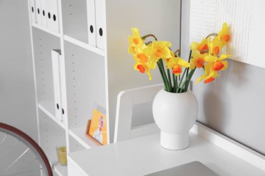 Ofisin içindeki masanın üzerinde çiçek açan vazo.