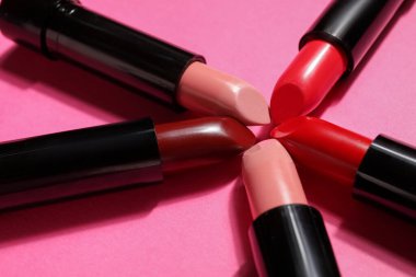 Pembe arka planda farklı ruj izleri, yakın plan.