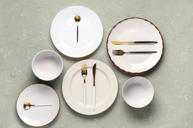 Gri grunge masa üzerinde temiz tabaklar, kaseler ve çatal bıçak seti.